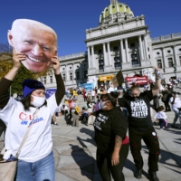 Supporters of Democratic U.S. presidential nominee Joe Biden dance in celebration of his declared victory in Harrisburg, Pennsylvania, on Saturday. | AP 