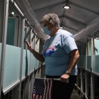 Hyla Winters assists a voter as she works at an election site in Las Vegas on Oct. 29. Winters, 71, a devout evangelical and regular attendee of a Las Vegas megachurch, voted for Trump in 2016. But over time, she became disheartened by his attacks on perceived enemies. | REUTERS