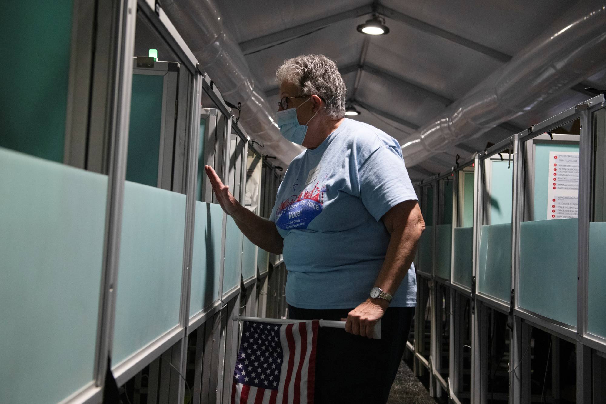 Hyla Winters assists a voter as she works at an election site in Las Vegas on Oct. 29. Winters, 71, a devout evangelical and regular attendee of a Las Vegas megachurch, voted for Trump in 2016. But over time, she became disheartened by his attacks on perceived enemies. | REUTERS