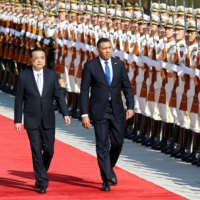 Jamaican Prime Minister Andrew Holness reviews the honor guard during a welcome ceremony with Chinese Premier Li Keqiang outside the Great Hall of the People in Beijing in November 2019.  | REUTERS