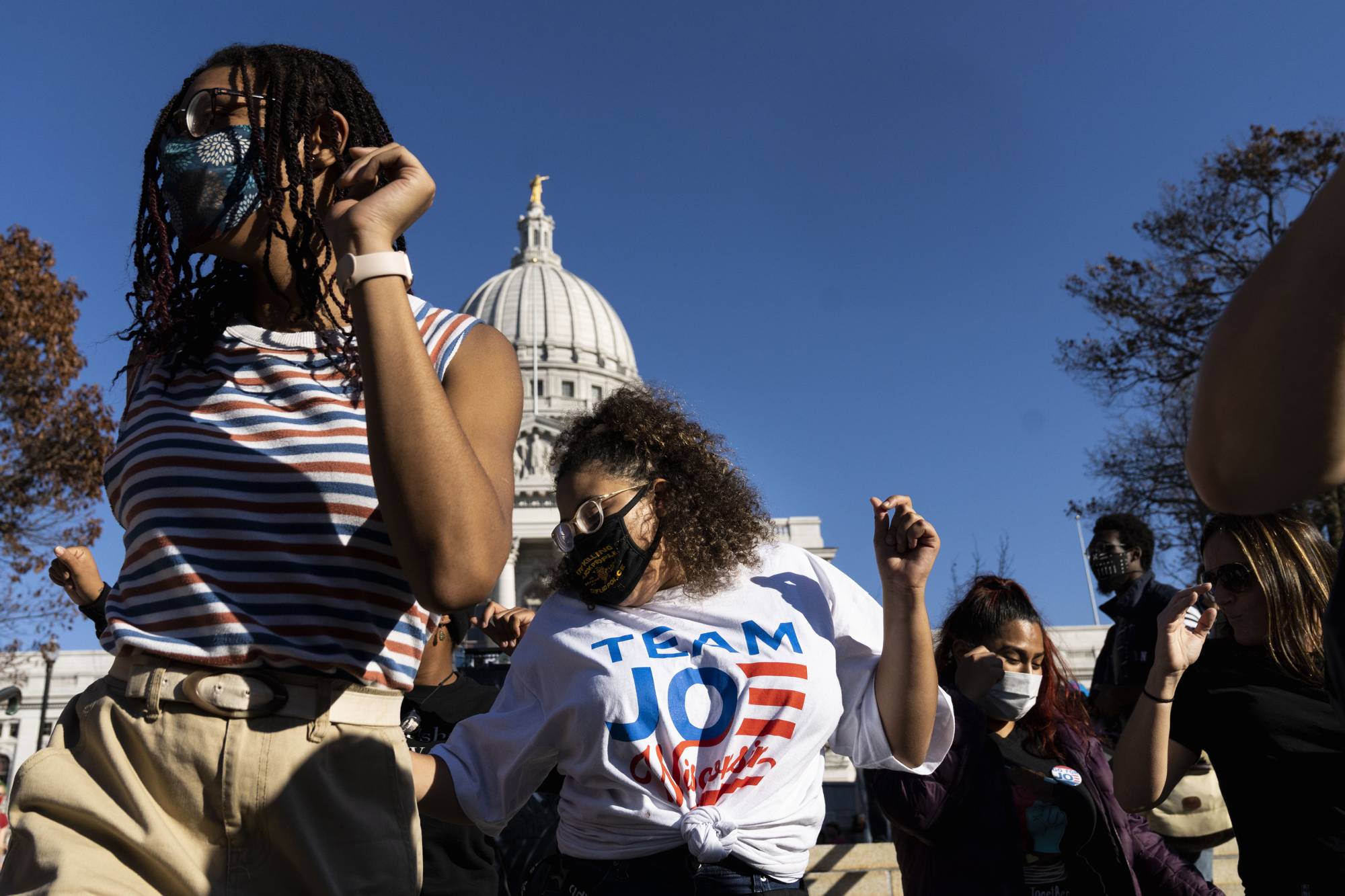 Biden supporters dance outside the Wisconsin State Capitol in Madison on Saturday. | Lauren Justice / The New York Times