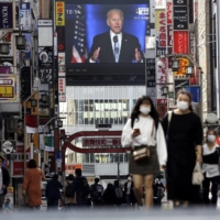 A screen shows a live broadcast of U.S. President-elect Joe Biden speaking Sunday, in Tokyo\'s Shinjuku Ward. | AP