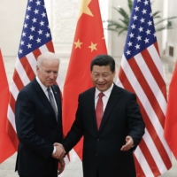 Chinese President Xi Jinping shakes hands with then U.S. Vice President Joe Biden as they pose for photos at the Great Hall of the People in Beijing. | AP