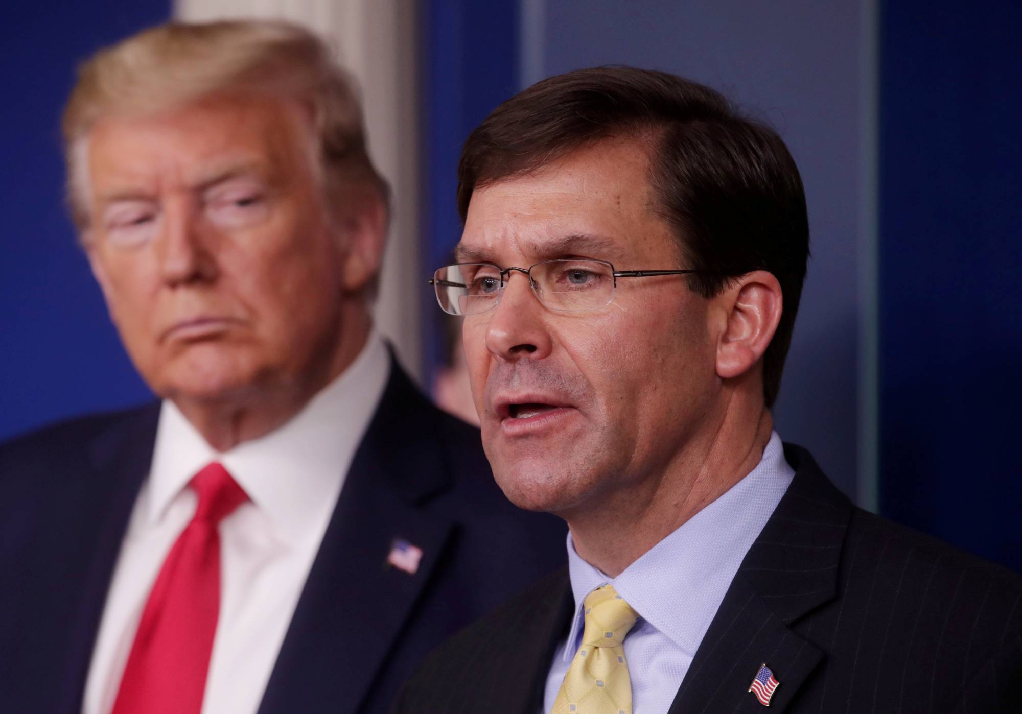 U.S. Defense Secretary Mark Esper address the daily White House coronavirus response briefing as President Donald Trump listens at the White House in Washington in March. | REUTERS