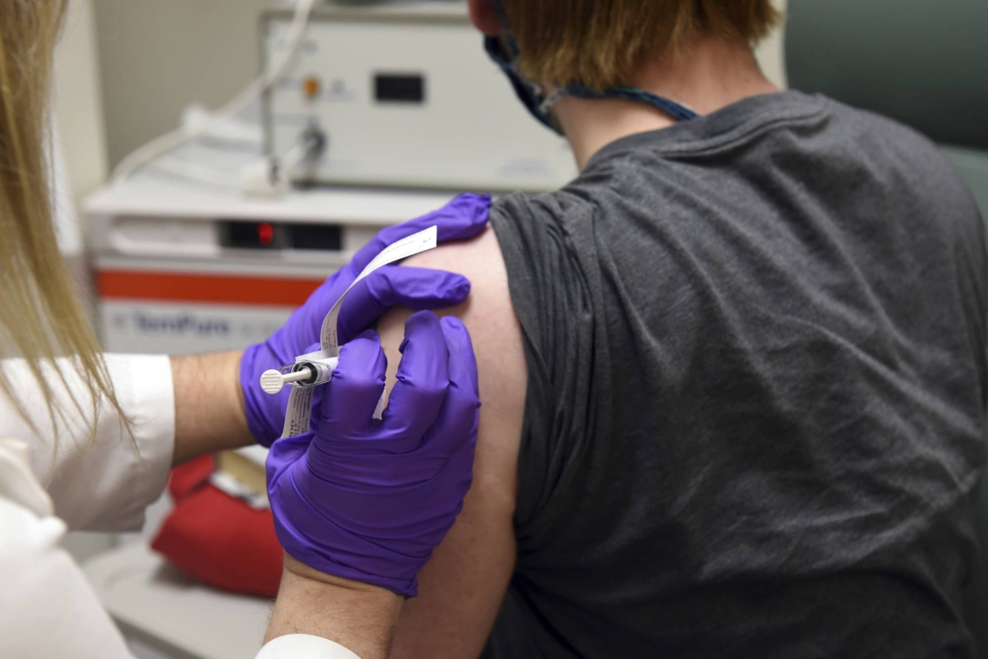 A person enrolled in Pfizer's COVID-19 vaccine clinical trial is vaccinated at the University of Maryland School of Medicine in Baltimore in May. | UNIVERSITY OF MARYLAND SCHOOL OF MEDICINE / VIA AP