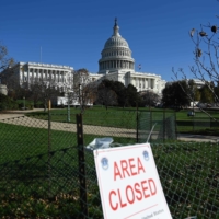 Construction workers begin work on the presidential inaugural platform in front of the U.S. Capitol on Monday.  | AFP-JIJI