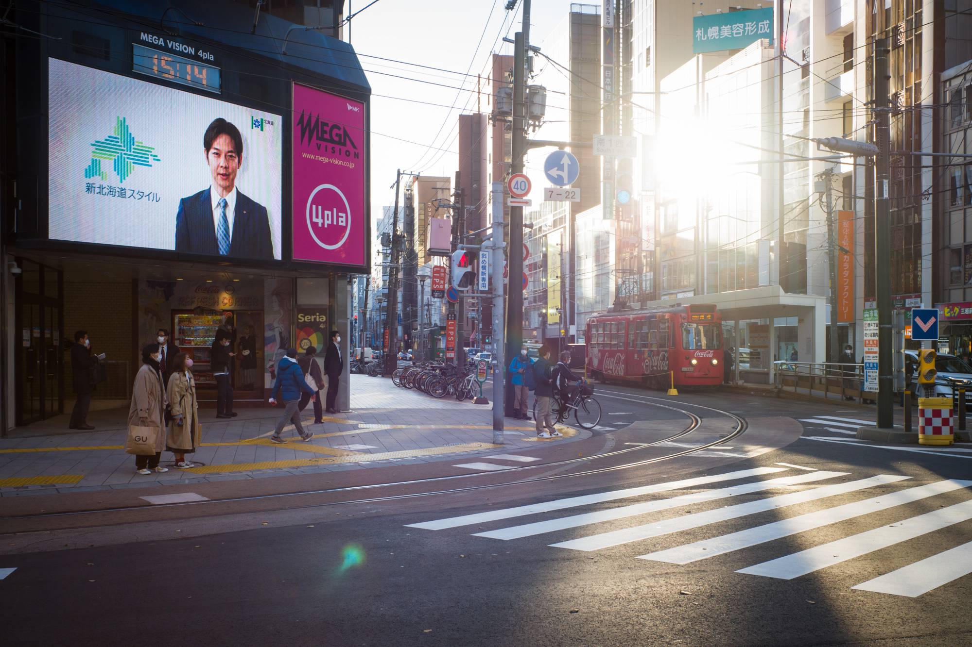 A screen features Hokkaido Gov. Naomichi Suzuki delivering a coronavirus public information message at a junction in Sapporo on Thursday. | BLOOMBERG