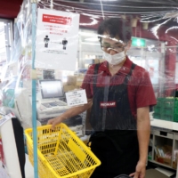A supermarket in Hiroshima offers baskets of a different color to shoppers as they browse the aisles, so they will stand out if they pack their groceries into personal bags without going through cashiers. | CHUGOKU SHIMBUN
