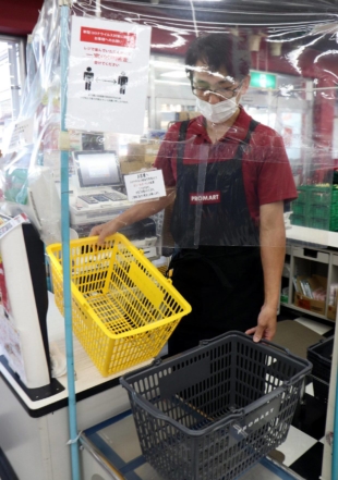 A supermarket in Hiroshima offers baskets of a different color to shoppers as they browse the aisles, so they will stand out if they pack their groceries into personal bags without going through cashiers. | CHUGOKU SHIMBUN 