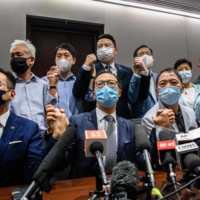 Pro-democracy lawmakers join hands at the start of a news conference at a Legislative Council office in Hong Kong on Wednesday. | AFP-JIJI