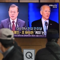 A news report shown at a railway station in Seoul on Monday shows South Korean President Moon Jae-in and U.S. President-elect Joe Biden.
 | AFP-JIJI