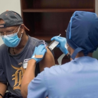 A volunteer is given the Moderna COVID-19 vaccine candidate in August in Detroit. | HENRY FORD HEALTH SYSTEM / VIA AFP-JIJI