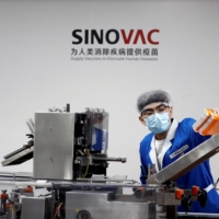 A man works in a Beijing packaging facility of Chinese vaccine-maker Sinovac Biotech, which is developing an experimental coronavirus disease vaccine, during a government-organized media tour on Sept. 24. | REUTERS