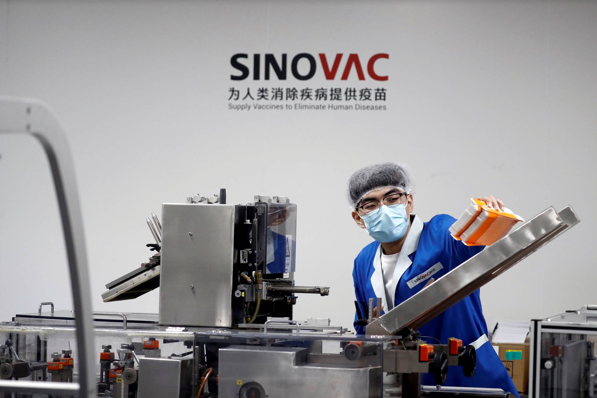 A man works in a Beijing packaging facility of Chinese vaccine-maker Sinovac Biotech, which is developing an experimental coronavirus disease vaccine, during a government-organized media tour on Sept. 24. | REUTERS