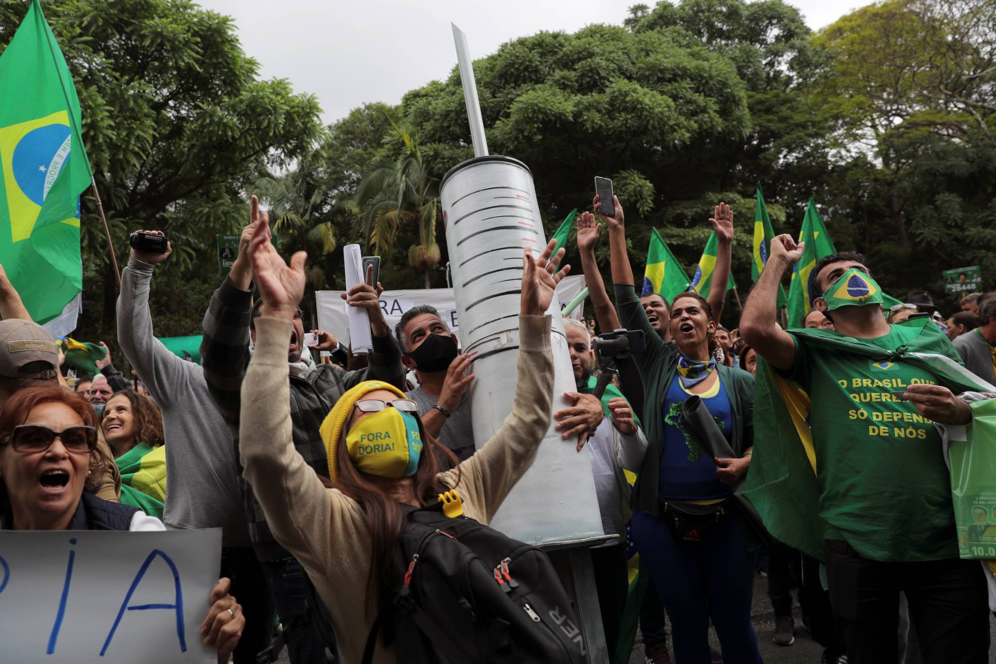 Demonstrators carry a giant syringe as they protest against Sinovac's potential COVID-19 vaccine in Sao Paulo on Nov. 1. | REUTERS