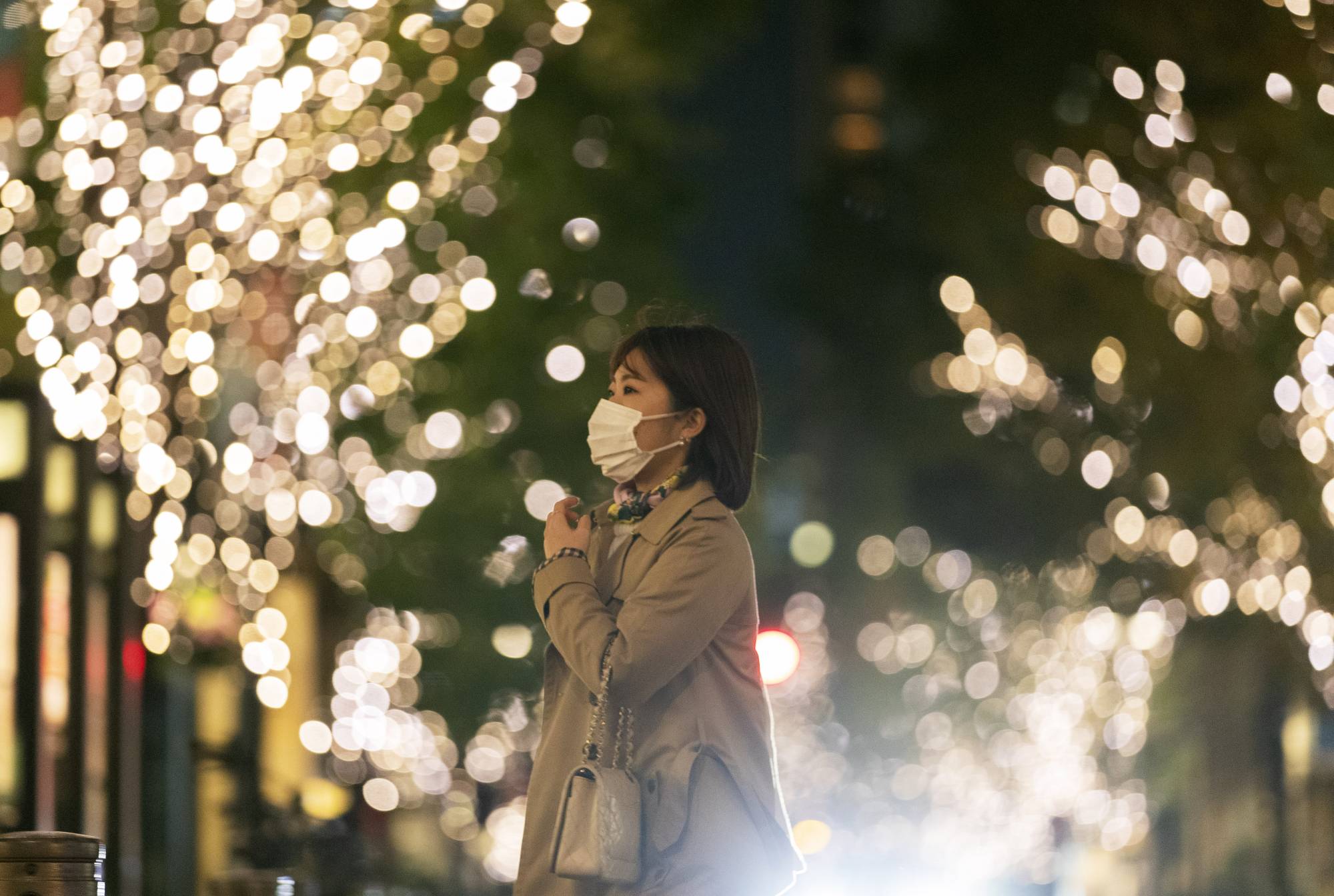 A woman walks down a street decorated with seasonal lighting in Tokyo on Thursday. | AP