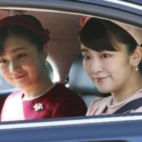 Princess Mako (right) travels with her sister Princess Kako in February. | POOL / VIA KYODO
