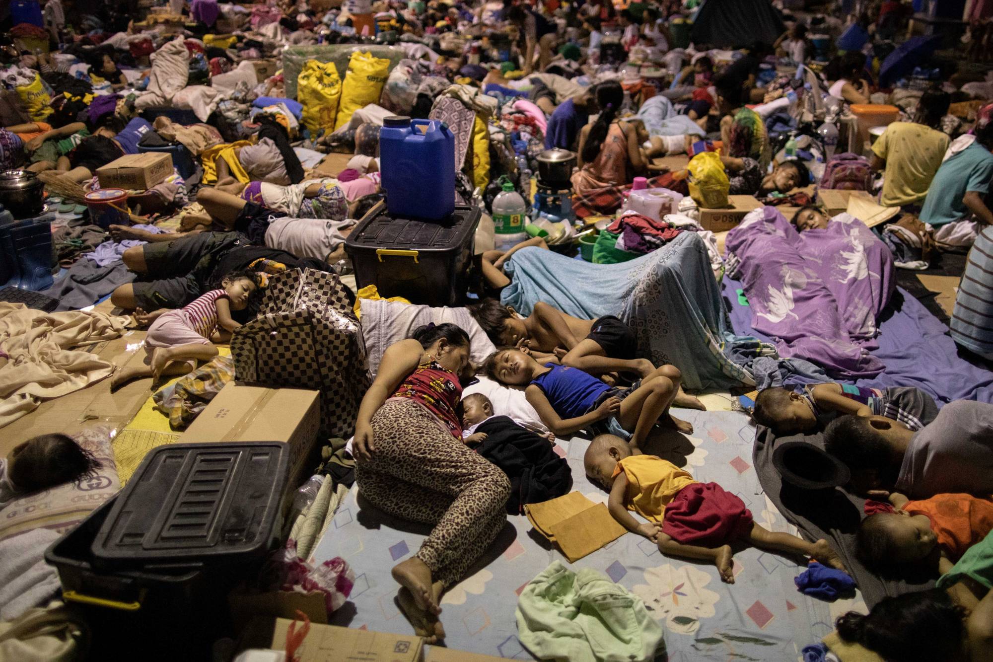 Residents affected by the onslaught of Typhoon Vamco sleep at a basketball court turned into an evacuation center, in San Mateo, Philippines, on Saturday. | REUTERS