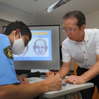 Shuichi Abe (right) teaches students how to draw portraits for criminal cases at the police academy in Miyagi Prefecture. | KAHOKU SHIMPO
