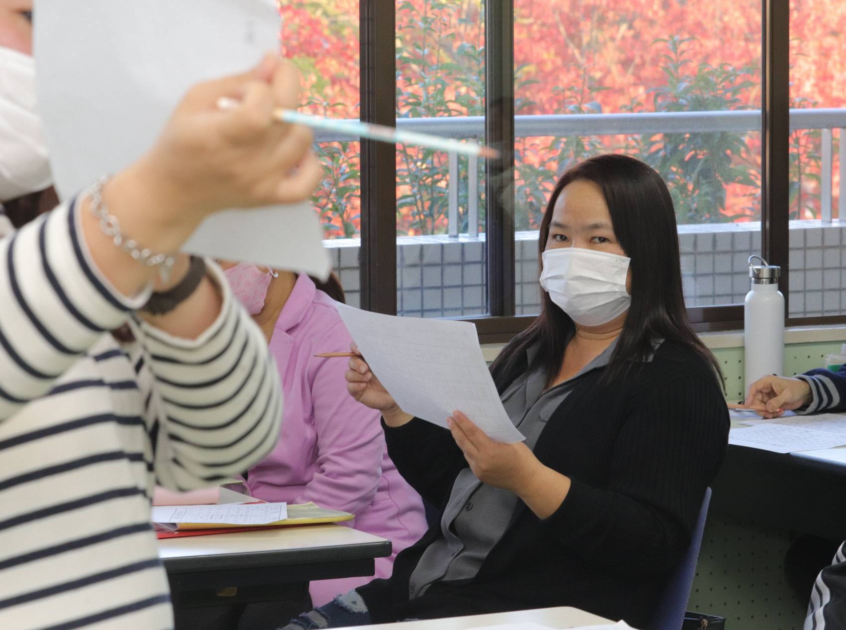 Raquel Garcia, a third generation Japanese-Filipino who lost her job at a factory in Mie Prefecture earlier this month, studies Japanese at a labor union gathering on Nov. 11 in Matsusaka. | CHUNICHI SHIMBUN