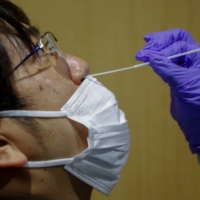 A man undergoes a simulated PCR test at the newly opened Narita International Airport PCR Center in Chiba Prefecture on Nov. 2. | REUTERS