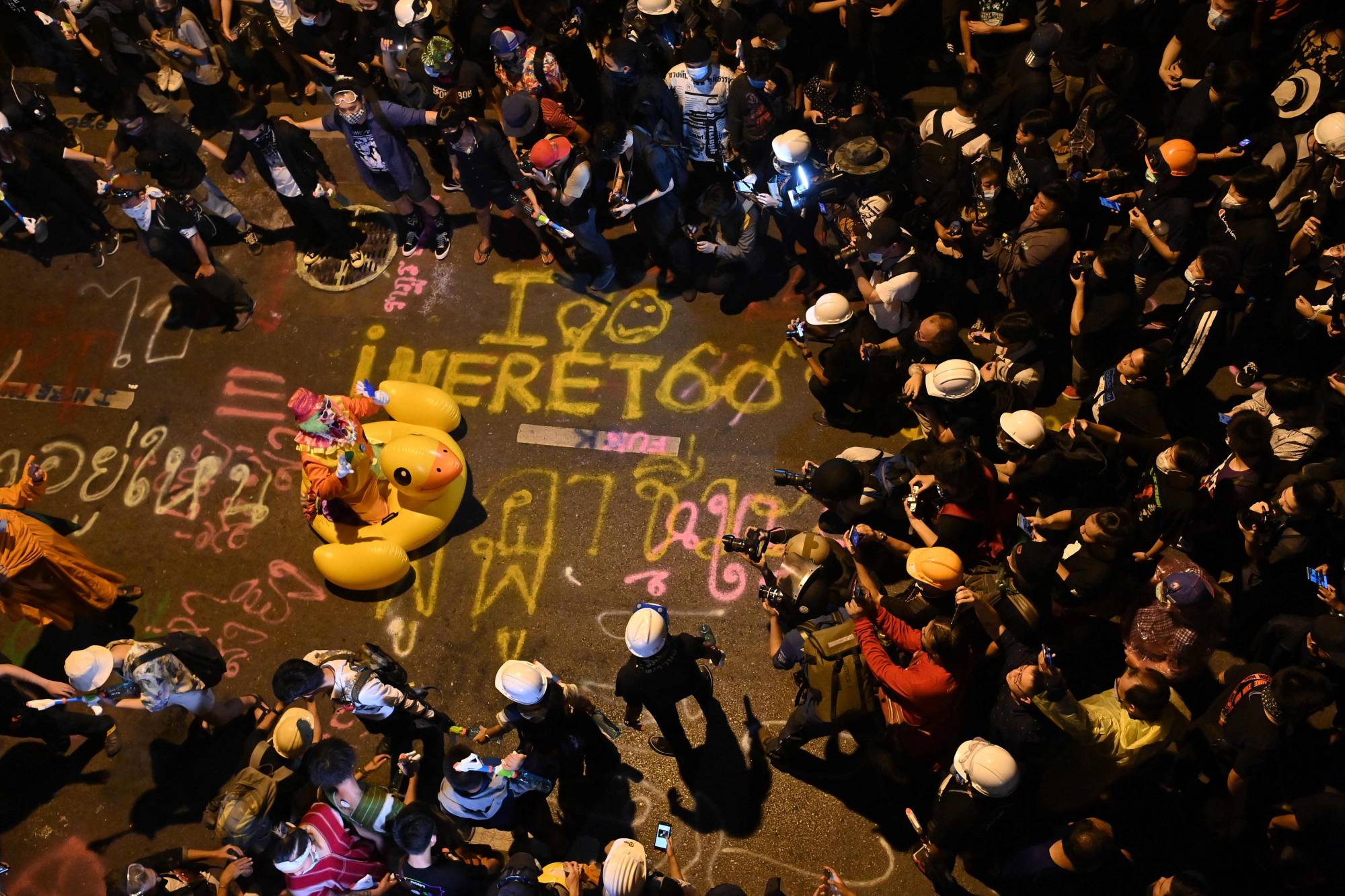 Members of the media take pictures of a clown on an inflatable oversized duck as pro-democracy protesters take part in an anti-government rally in Bangkok on Wednesday. | AFP-Jiji