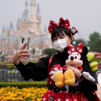 Happiest place on Earth: A visitor wearing a protective face mask takes a selfie at Shanghai Disney Resort. The Shanghai Disneyland theme park reopened on May 11 after a shutdown due to the COVID-19 outbreak. | REUTERS / ALY SONG