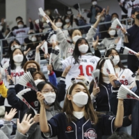 Fans wearing face masks as a precaution against the coronavirus cheer during the Game 4 of the Korean Series, the Korea Baseball Organization\'s championship round, between Doosan Bears and NC Dinos at Gocheok Sky Dome in Seoul on  Saturday. | AP