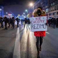 A demonstrator holds a placard next to police officers during a pro-choice protest in the streets of central Warsaw earlier this month.  | AFP-JIJI