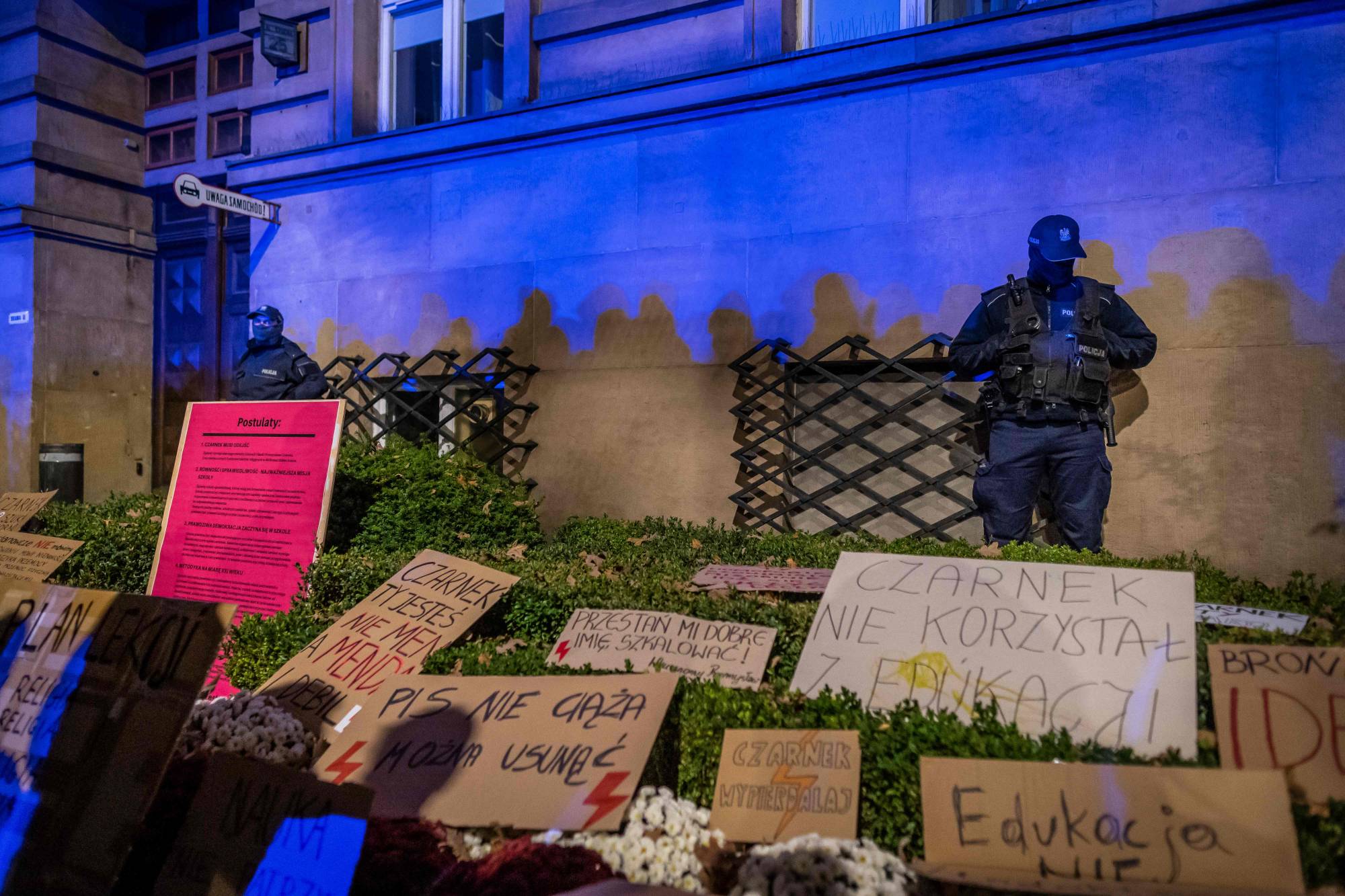 Police officers stand guard in front of the Education Ministry where protesters left banners, earlier this month in Warsaw. | AFP-JIJI