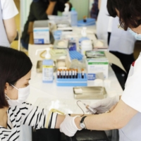 A nurse takes a blood sample from a resident in Natori, Miyagi Prefecture, on June 1 as part of a program to test people for COVID-19 antibodies. | KYODO
