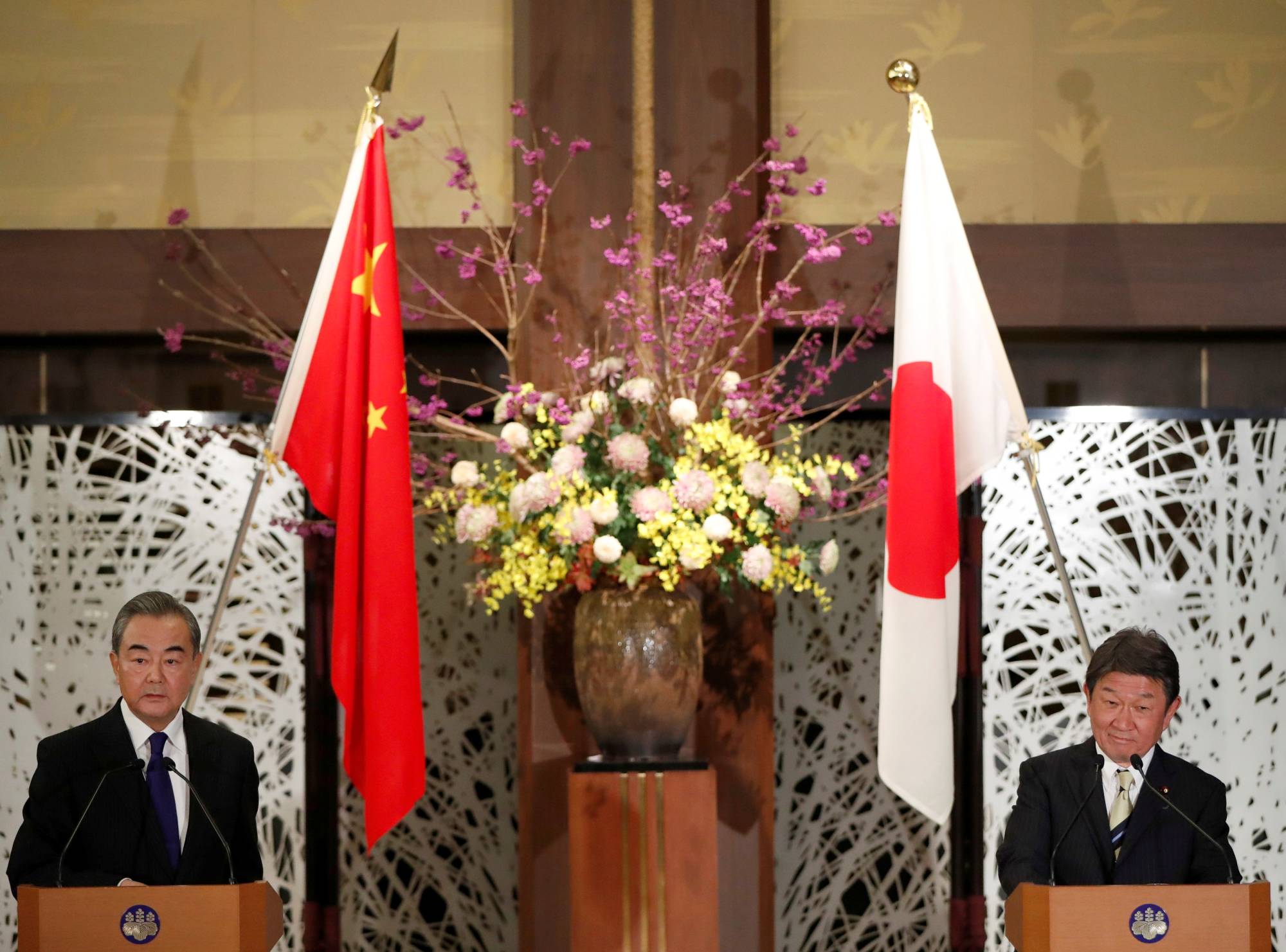 China's State Councilor and Foreign Minister Wang Yi (left) and his counterpart, Foreign Minister Toshimitsu Motegi, hold a joint news conference after their meeting in Tokyo on Tuesday. | POOL / VIA REUTERS 
