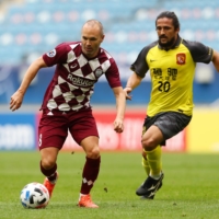 Vissel\'s Andres Iniesta is pursued by Evergrande\'s Luo Guofu during an Asian Champions League match on Saturday in Al Wakrah, Qatar. | REUTERS