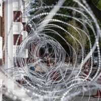 Razor wire lines a section of the perimeter wall at the Crown Property Bureau in Bangkok. | BLOOMBERG 