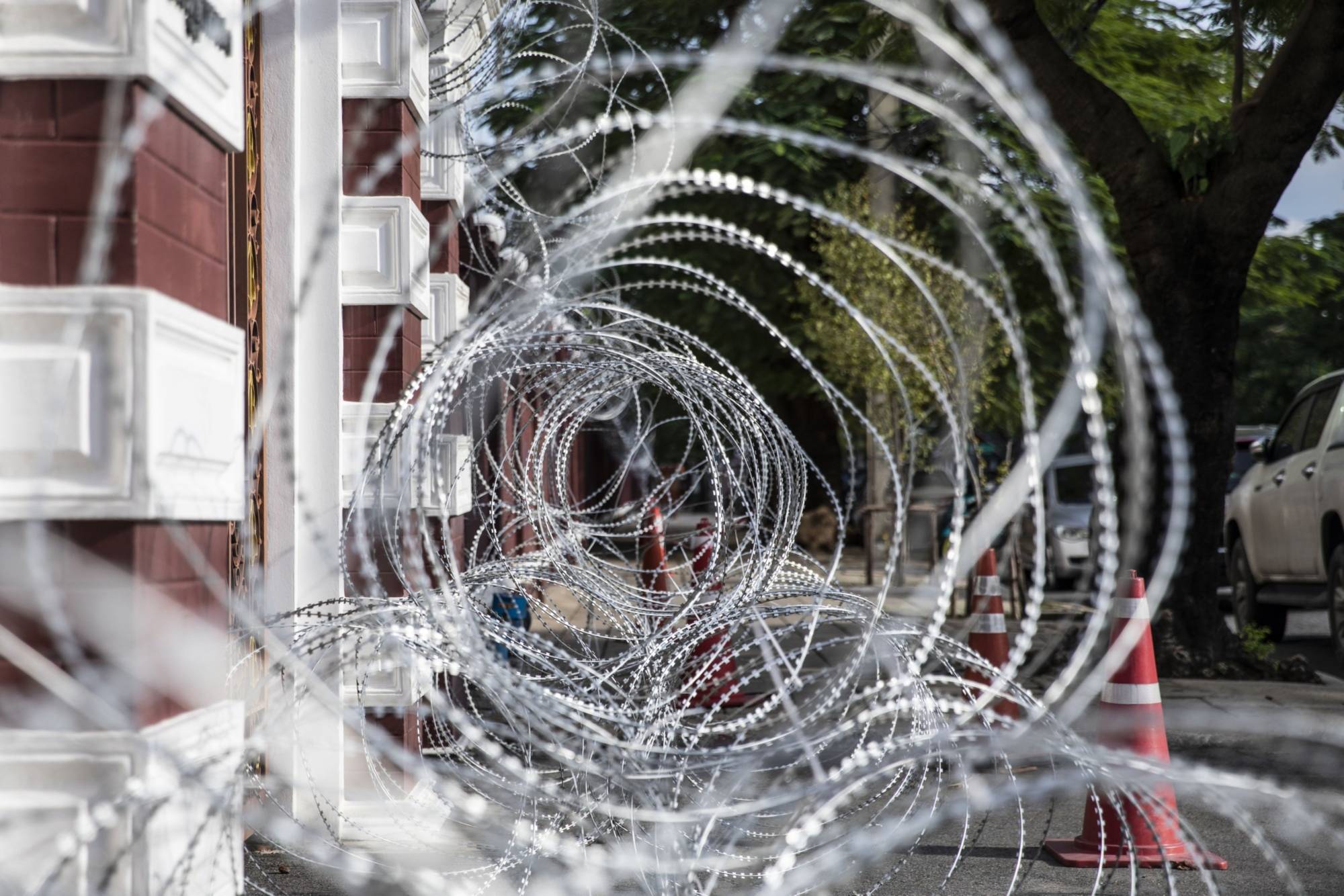 Razor wire lines a section of the perimeter wall at the Crown Property Bureau in Bangkok. | Bloomberg 