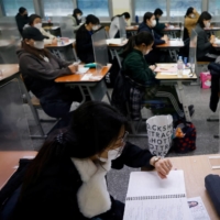 Students take university entrance exams on Thursday in Seoul.  | REUTERS