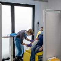 A volunteer undergoes testing in Oxford, England, as part of a vaccine trial by AstraZeneca and the University of Oxford on Nov. 19.  | ANDREW TESTA / THE NEW YORK TIMES