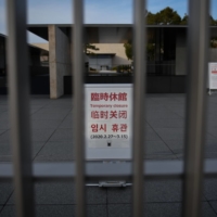 The tourism drop: A notice of temporary closure stands behind a gate at the Kyoto National Museum in March. With borders closed, the number of overseas tourists plummeted to almost zero. | BLOOMBERG