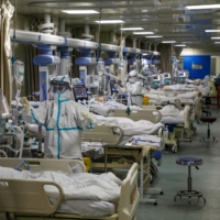 Medical workers attend to COVID-19 patients at a hospital in Wuhan, China, in February. | CHINA DAILY / VIA REUTERS
