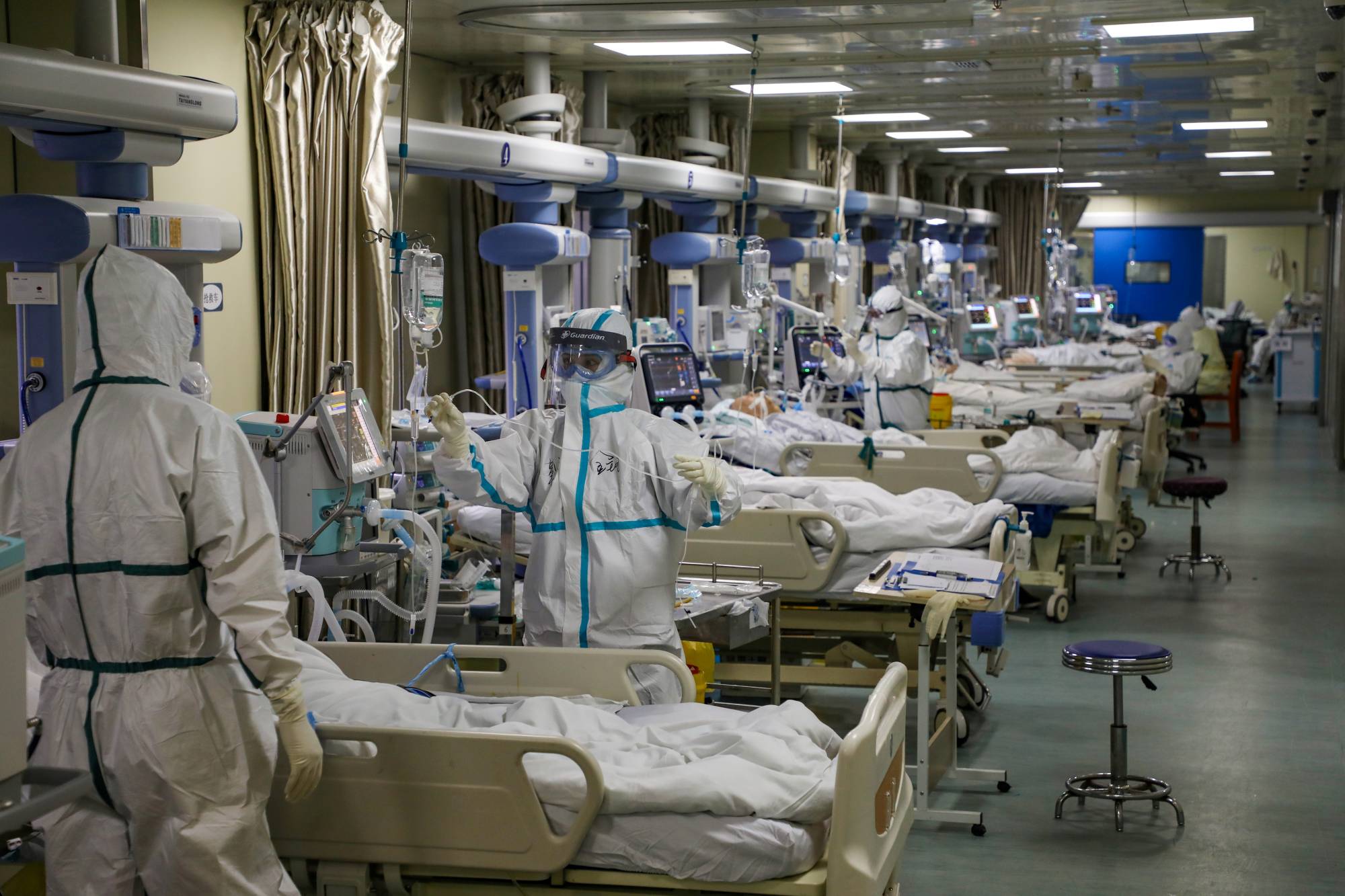 Medical workers attend to COVID-19 patients at a hospital in Wuhan, China, in February. | CHINA DAILY / VIA REUTERS