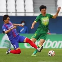 FC Tokyo\'s Masato Morishige (left) and Beijing\'s Lei Li vie for the ball during their Asian Champions League match on Sunday in Qatar. | REUTERS