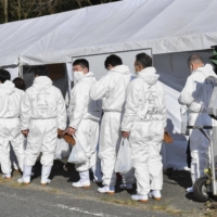 Officials respond to a bird flu outbreak at a poultry farm in Mihara, Hiroshima Prefecture, on Monday. | KYODO
