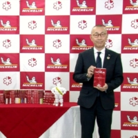 Nihon Michelin Tire Co. officials show The Michelin Guide Tokyo 2021 in Tokyo on Monday. | KYODO