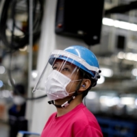 An employee works on a Mitsubishi assembly line in Kawasaki on May 18. | REUTERS