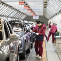 Employees make checks at an inspection line during a media tour of the Nio Inc. production facility in Hefei, Anhui province, China, on Dec. 4. Nio is cementing its role as a challenger to Tesla Inc. in China\'s premium electric vehicle segment, with both companies benefiting as the coronavirus pandemic recedes in the country.  | BLOOMBERG