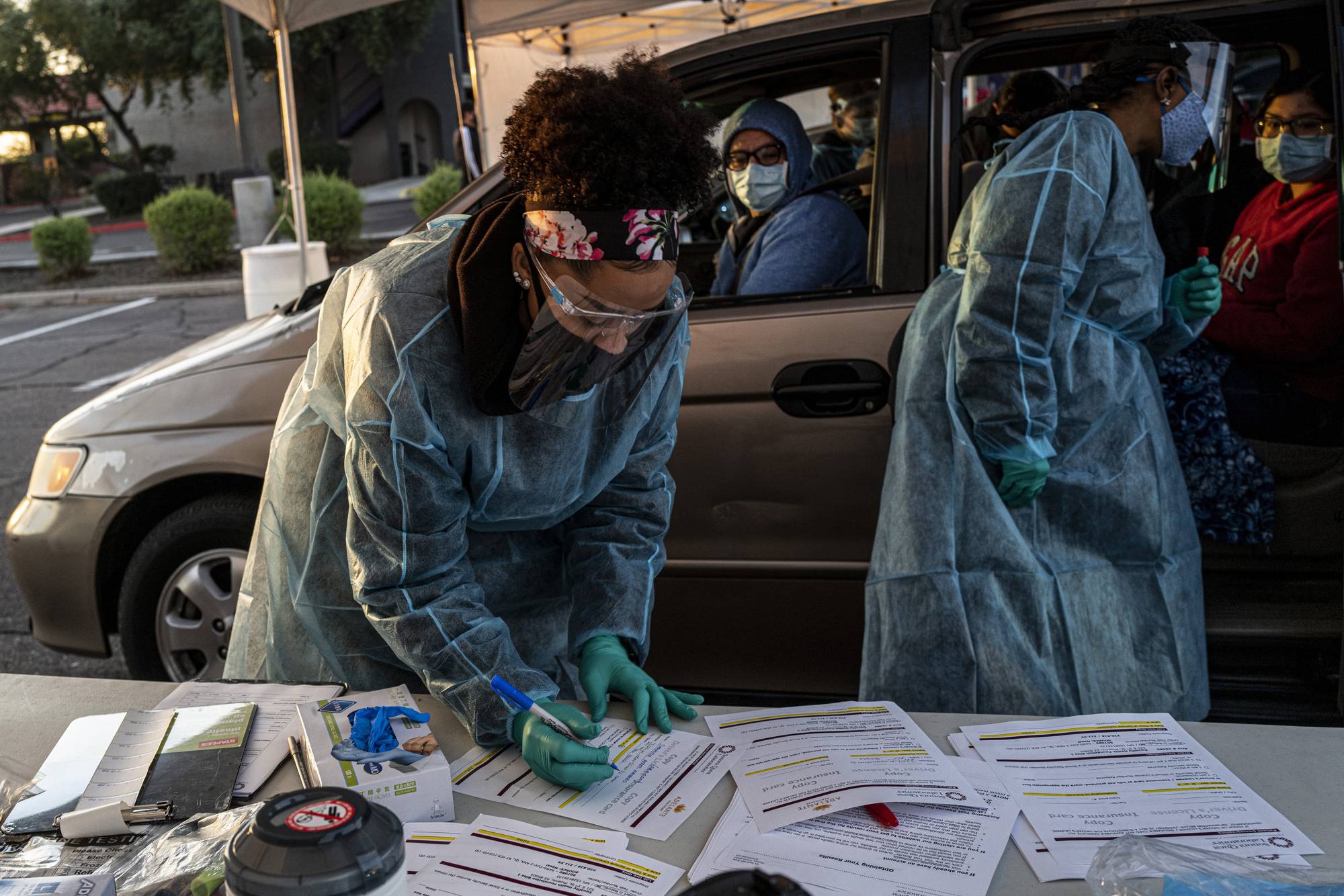 Health care workers at a COVID-19 drive-thru testing site at Grand Canyon University in Phoenix on Dec. 12. China stamped out the coronavirus, Communist Party messaging goes, with a resolve beyond the reach of flailing Western democracies. | Adriana Zehbrauskas / The New York Times
