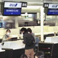 Passengers go through boarding procedures at an All Nippon Airways check-in counter for the airline\'s inaugural flight to Shenzhen at Narita Airport in Chiba Prefecture on Monday. | KYODO
