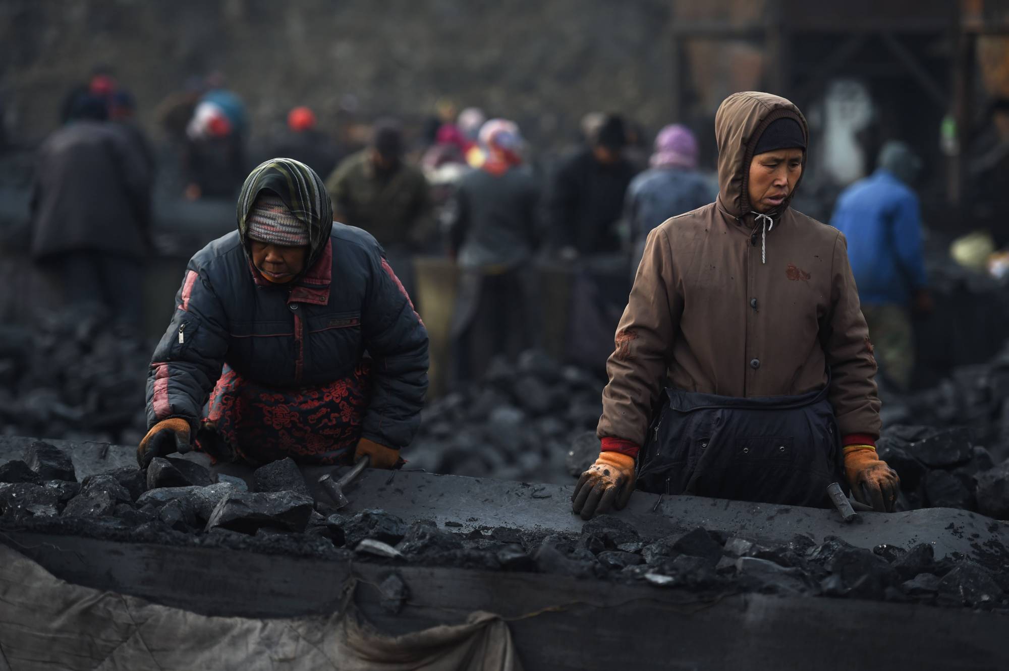 Workers sort coal near a mine in Datong, in China's northern Shanxi province, in November 2015. | AFP-JIJI