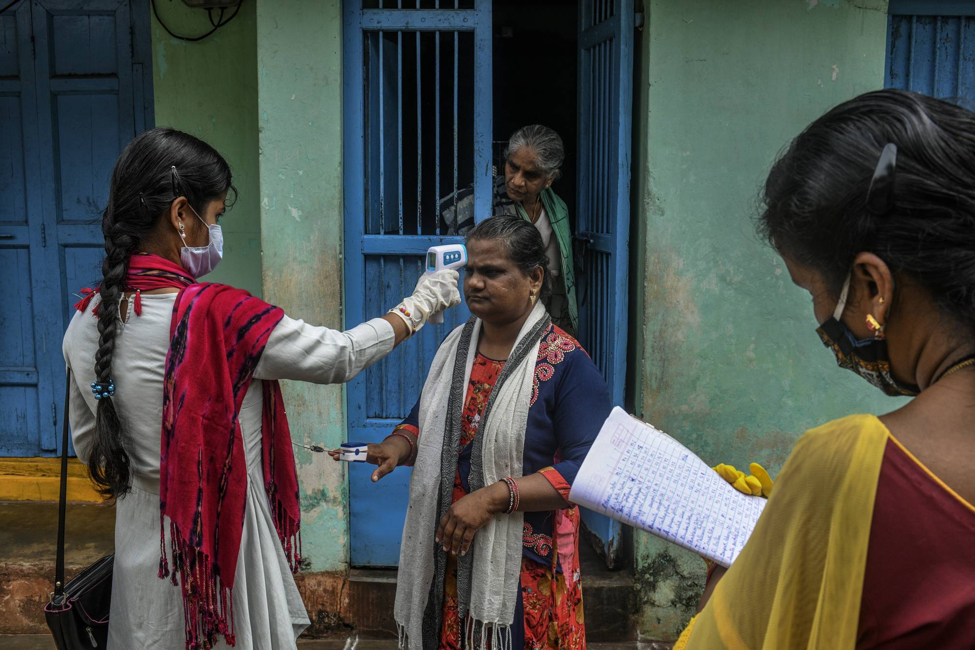 A health care worker conducts an examination in Ganjam, a rural district of India that was untouched by the coronavirus until migrant workers began to return home. | Atul Loke / The New York Times