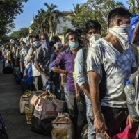 Migrant workers in Mumbai wait to board a train home to rural Bihar on May 20.  | ATUL LOKE / THE NEW YORK TIMES